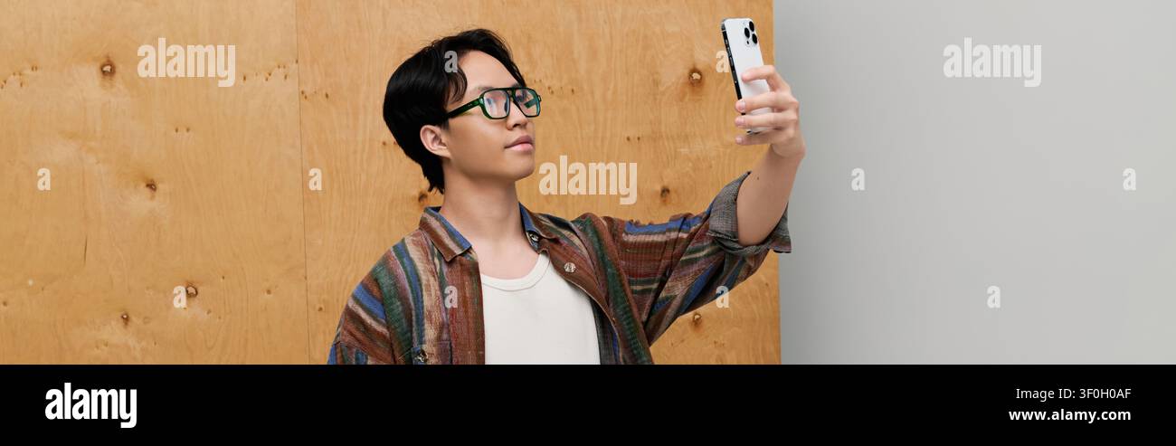 Young man with a handsome look takes a selfie while showcasing his elegant fashion sense. Stock Photo