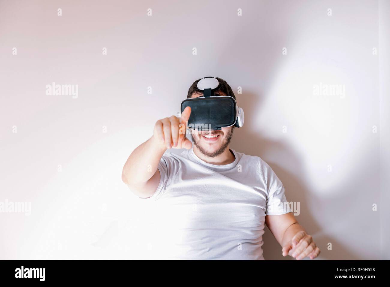 Man wearing a virtual reality headset and interacting with a digital interface Stock Photo