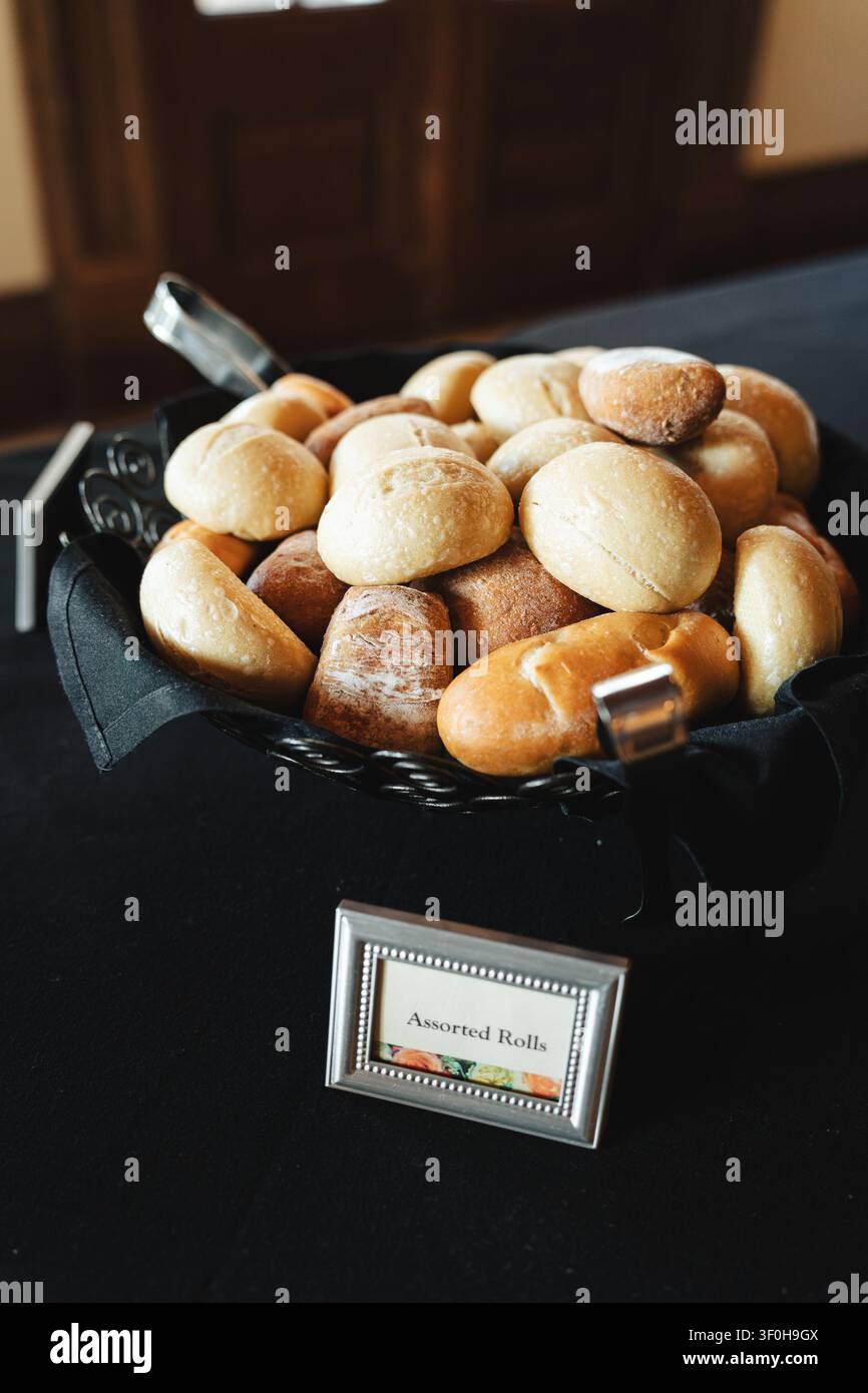 Assorted fresh bread rolls in a black fabric lined basket Stock Photo