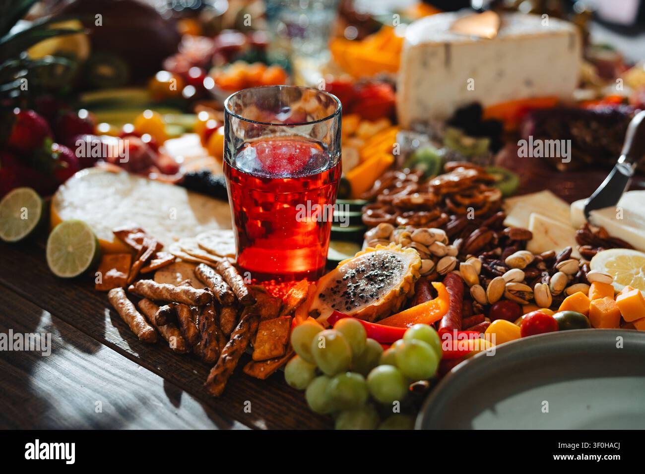 Abundant charcuterie board with red drink and assorted snacks Stock Photo