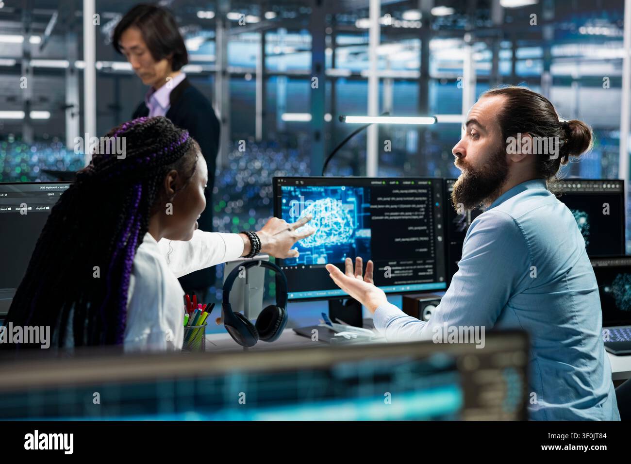 Programming team members resolve server connection problems in a server room with artificial intelligence support. Stock Photo
