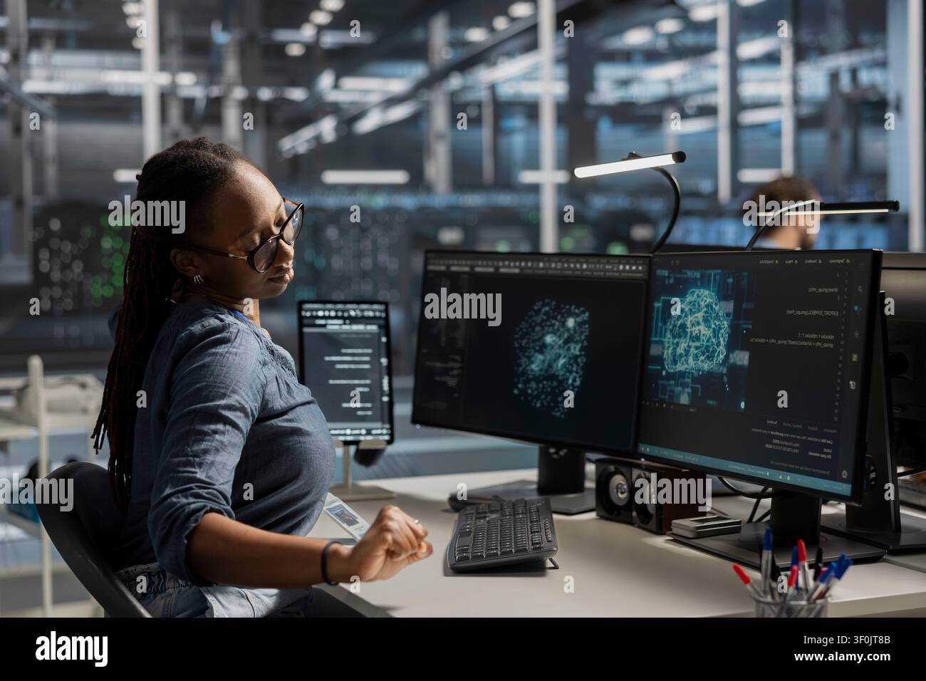 Technical specialist in server facility office working with AI powered tech to run simulations. Stock Photo