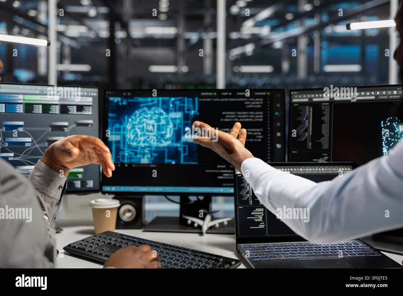 Server room technicians planning solutions, collaborating in office, working with AI computerized model. Stock Photo