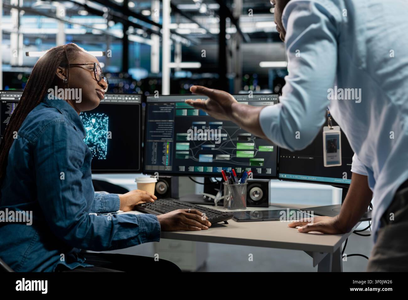 Data center collaborating engineers doing planning solutions, reviewing data analysis graph to reduce failures. Stock Photo
