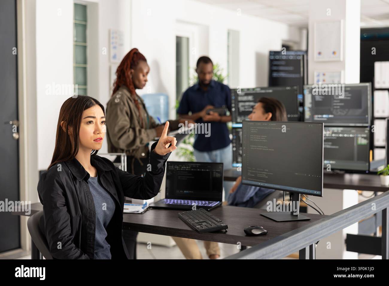 Female programmer works with 3d interface in office, testing code for web development. Innovative developer raises arms to interact with holographic screen while analyzing frontend data. Stock Photo