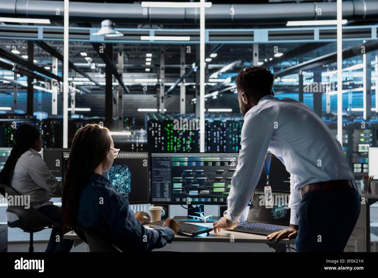 Server room manager supervises engineer working with AI visual programming to improve gear. Stock Photo