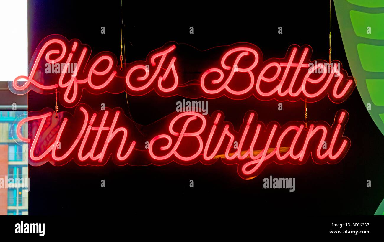 Red neon sign reading “Life Is Better With Biriyani” inside a contemporary Indian restaurant promoting the popular South Asian rice dish. Stock Photo