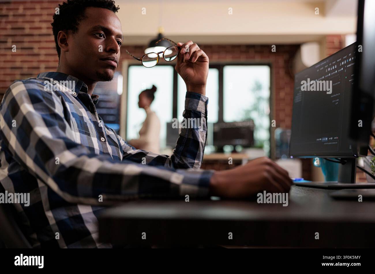 Pensive network engineer reflecting at failed data processing operation documents data protection, software systems and secure infrastructure in a technology workspace. Stock Photo