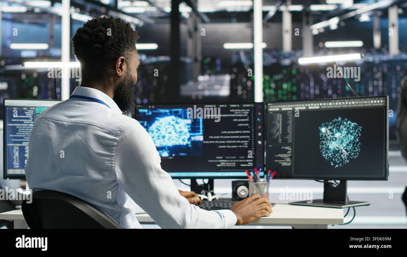 Supervisor supervising server facility systems engineer working with AI neural network models to set up hardware. Stock Photo