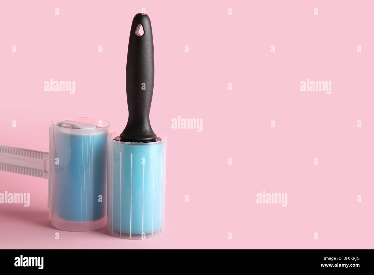 Different lint rollers on pink background Stock Photo