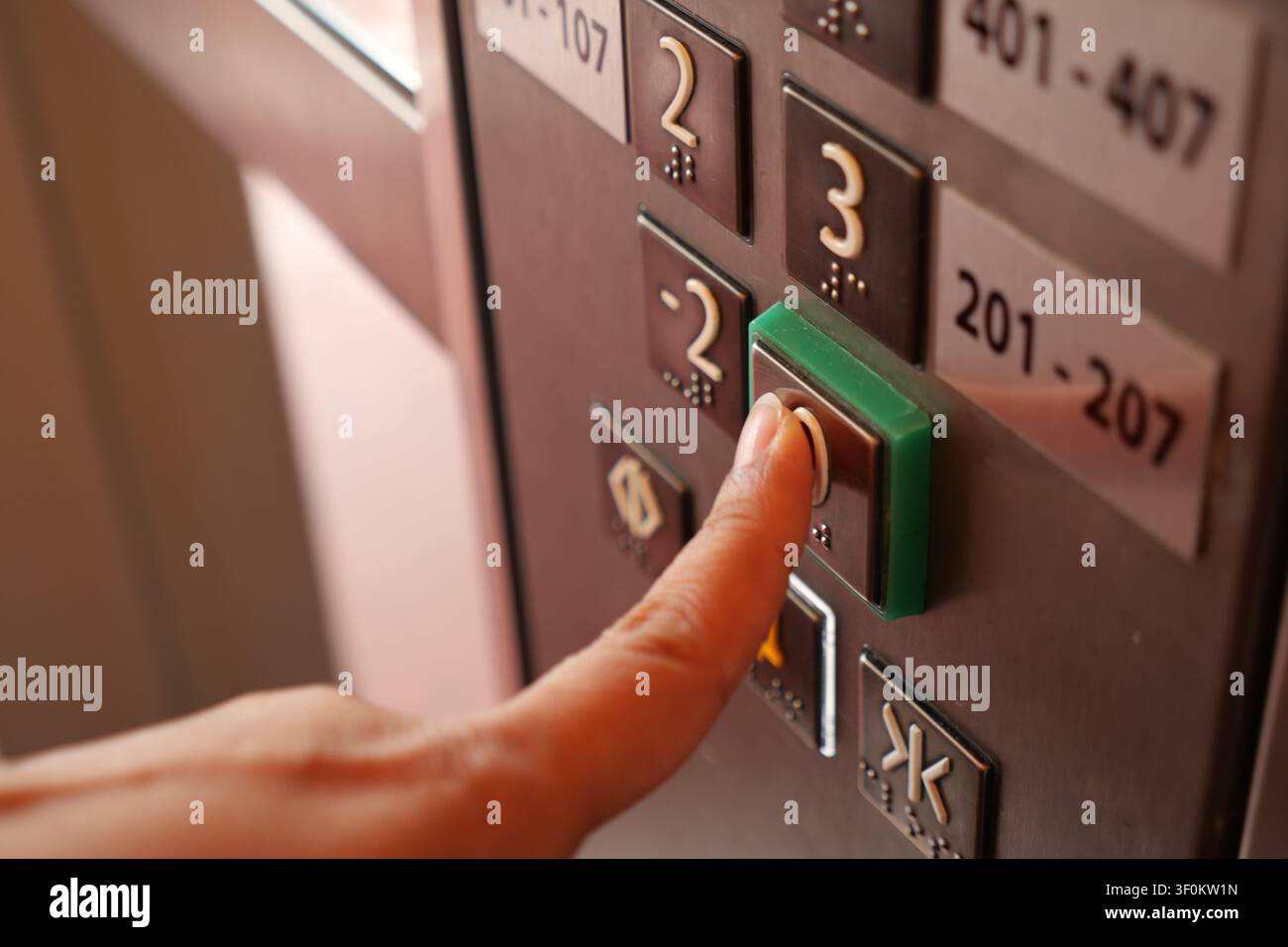 Pressing the elevator button in a bustling building Stock Photo