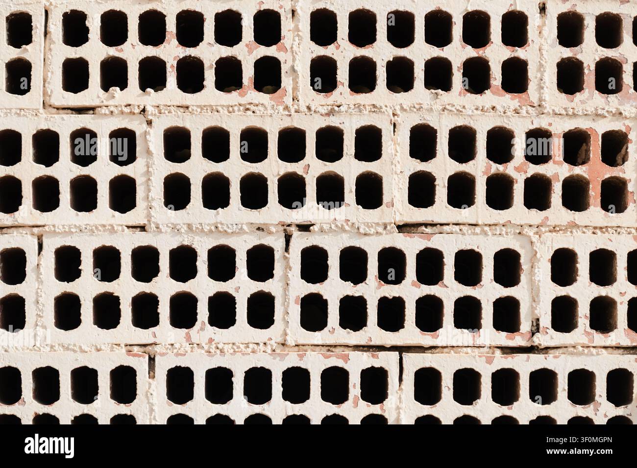 White Painted Wall made with Exposed Perforated Bricks Stock Photo