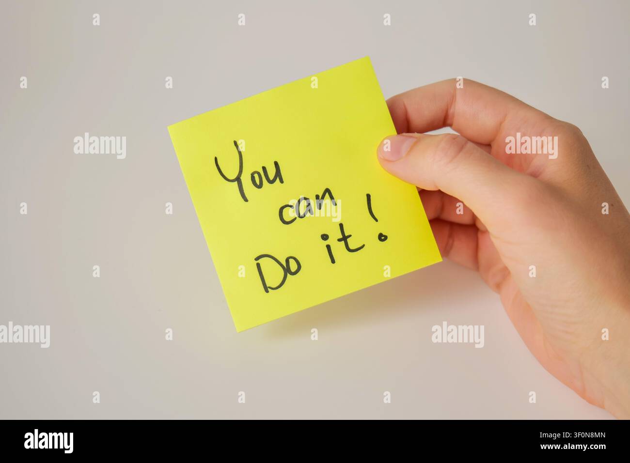 Hand Holding Yellow Sticky Note with You Can Do It Stock Photo