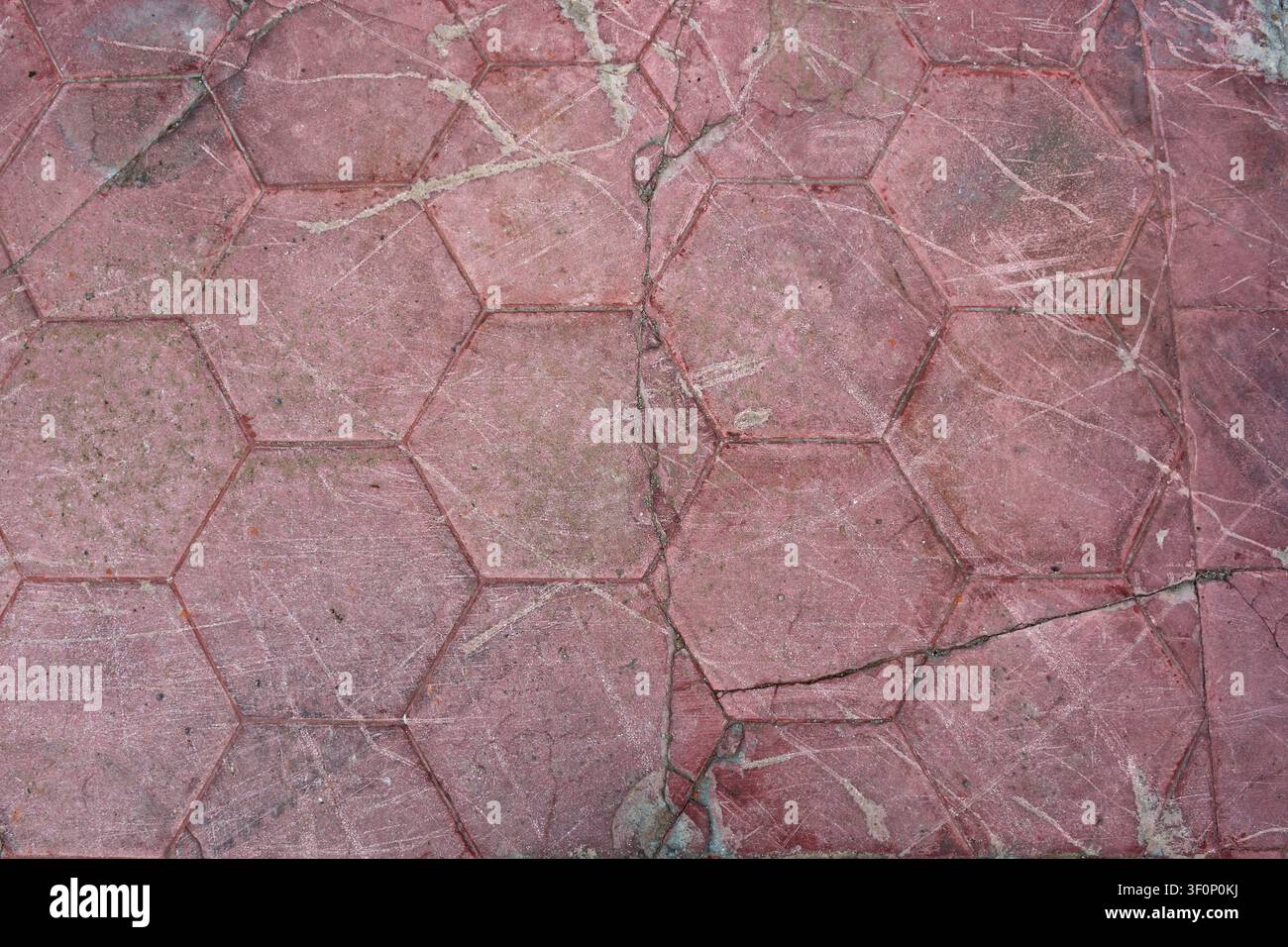 Aged red hexagonal tile floor texture with scratches and cracks Stock Photo
