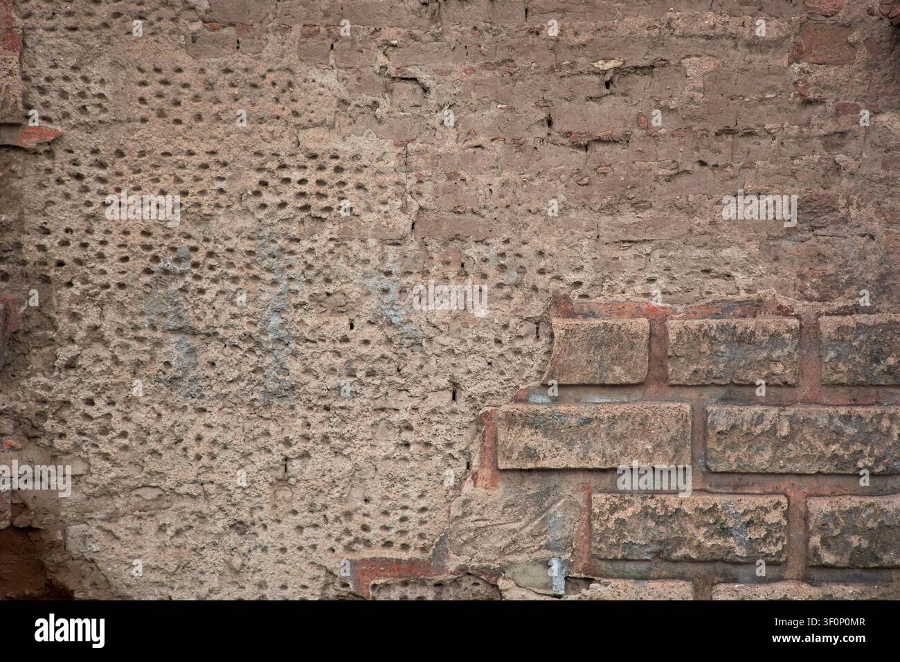 Old rustic wall background texture with chipped plaster, adobe and brick blocks Stock Photo