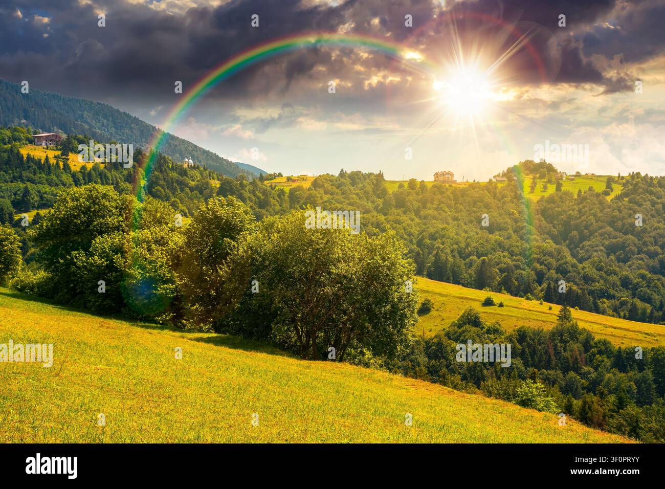 sunset over countryside mountain landscape of ukraine. rural fields and forested hills in evening light. remote place of mizhhirya district in transca Stock Photo