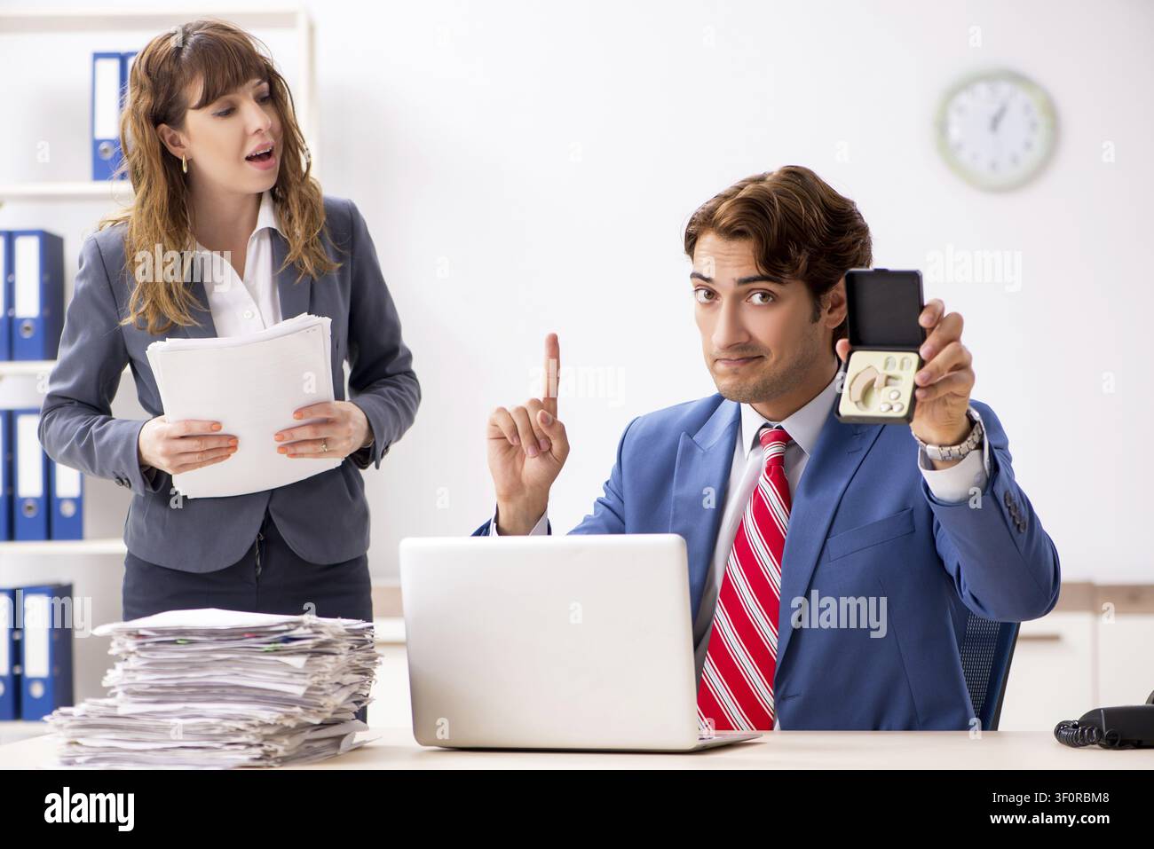 Deaf employee using hearing aid talking to boss Stock Photo