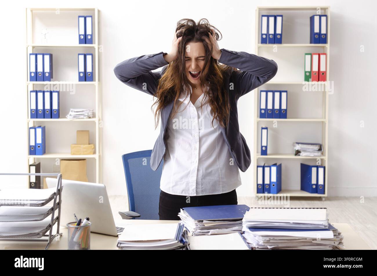 Young female employee unhappy with excessive work Stock Photo