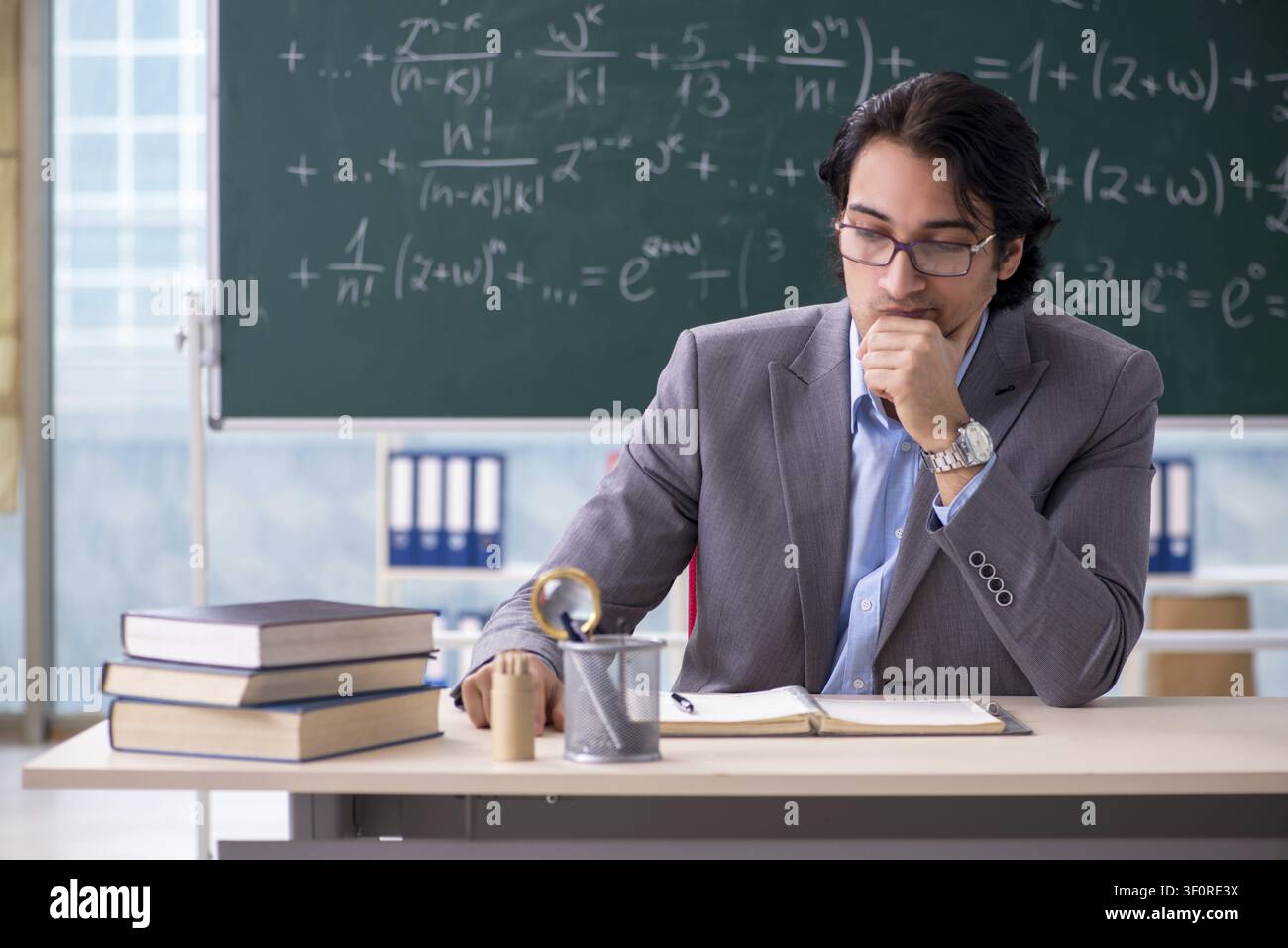 Young handsome math teacher in classroom Stock Photo