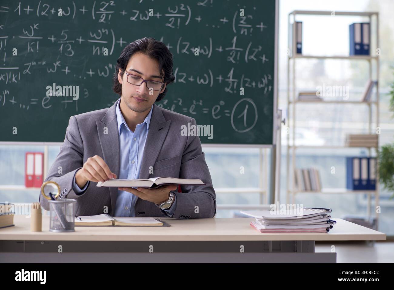 Young handsome math teacher in classroom Stock Photo