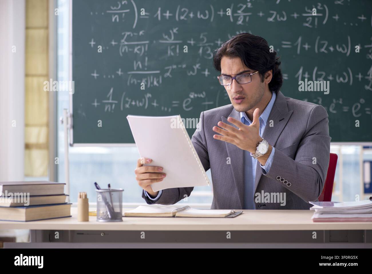 Young handsome math teacher in classroom Stock Photo