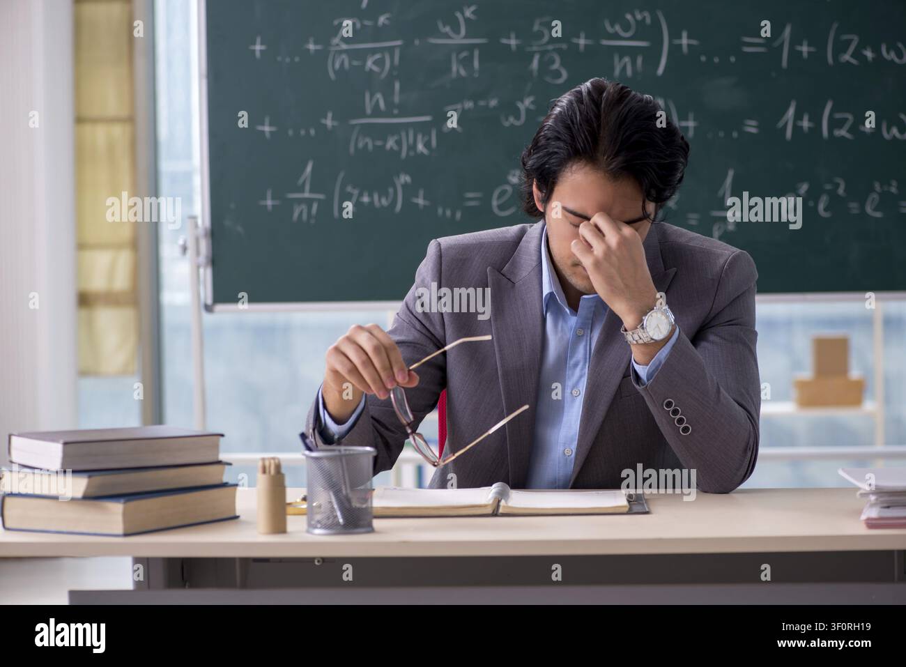 Young handsome math teacher in classroom Stock Photo