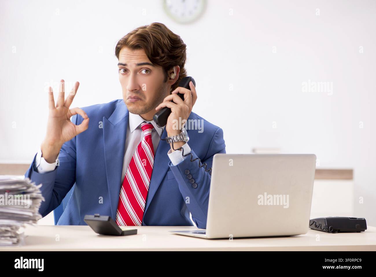 Deaf employee using hearing aid in office Stock Photo