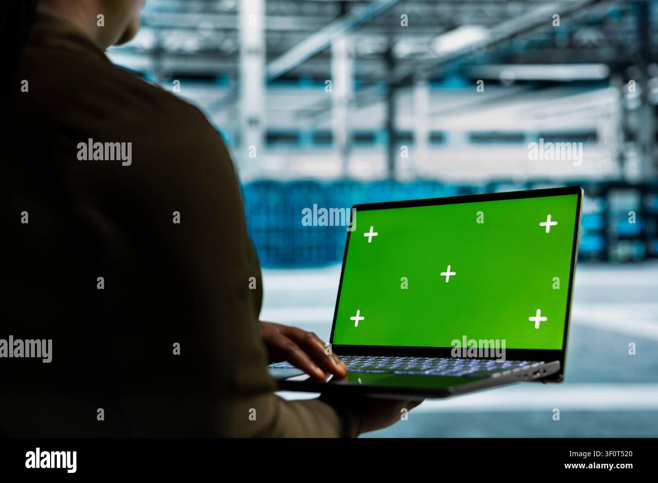 Data center programmer works with a chroma key laptop, using an editable screen to expand workload capacity. Stock Photo