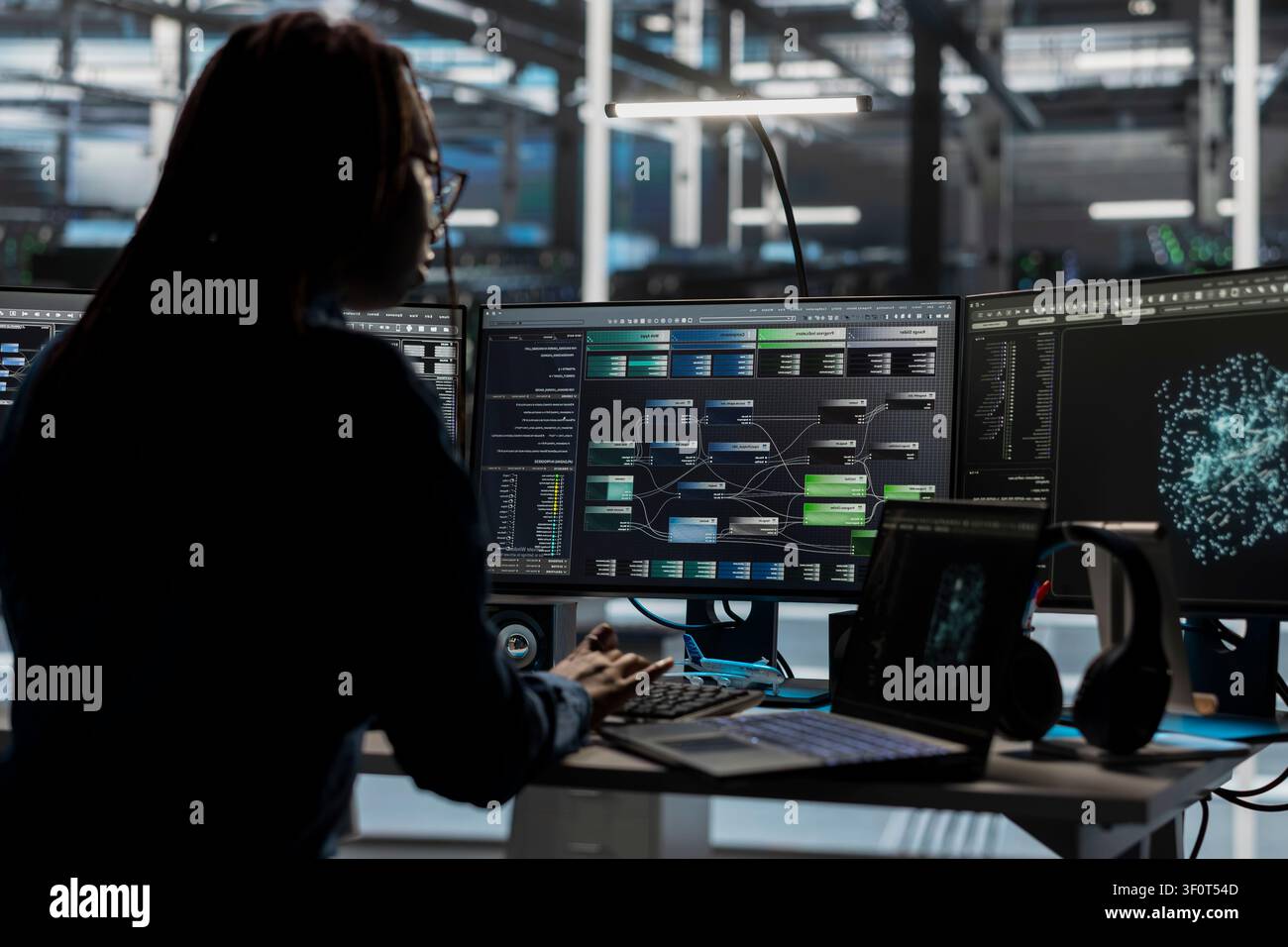 Server room software developer reviews AI visual analytics dashboard to pinpoint equipment performance problems. Stock Photo