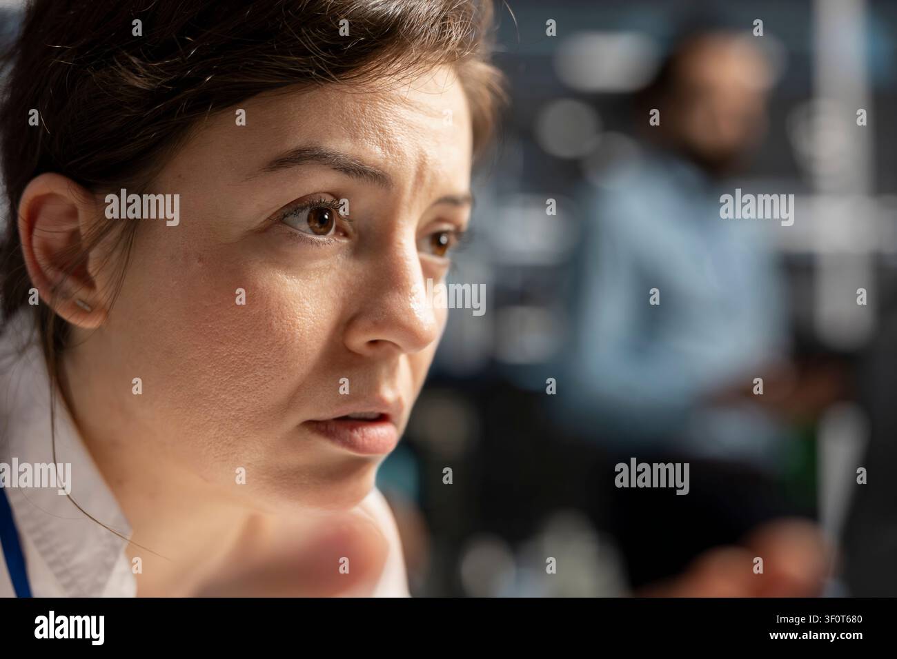 Concerned computer scientist reviews warning messages in a data center while troubleshooting errors affecting equipment performance. Stock Photo