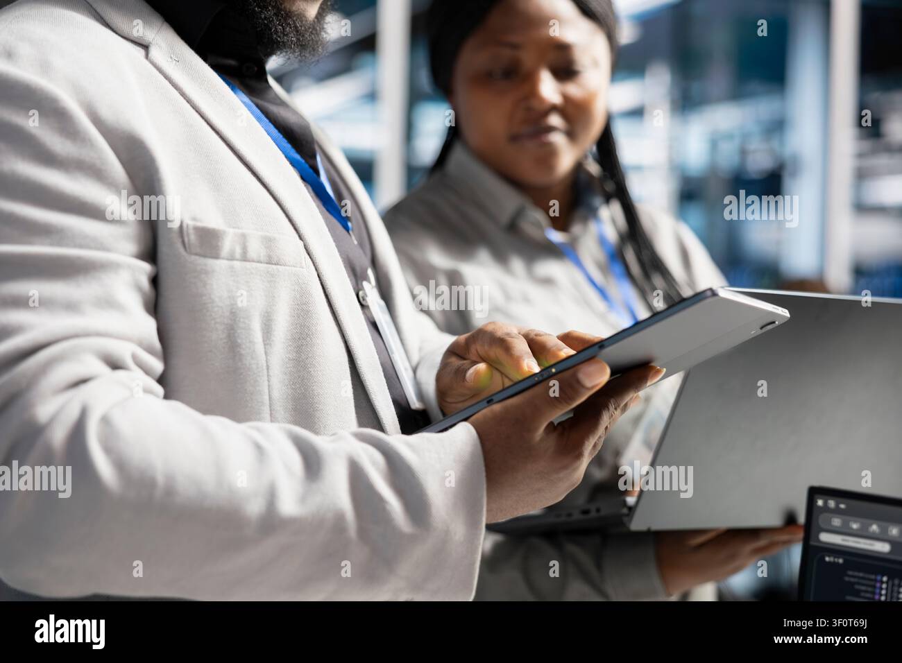 Data center software developer uses a tablet to update server software, supporting reliable infrastructure operations. Stock Photo