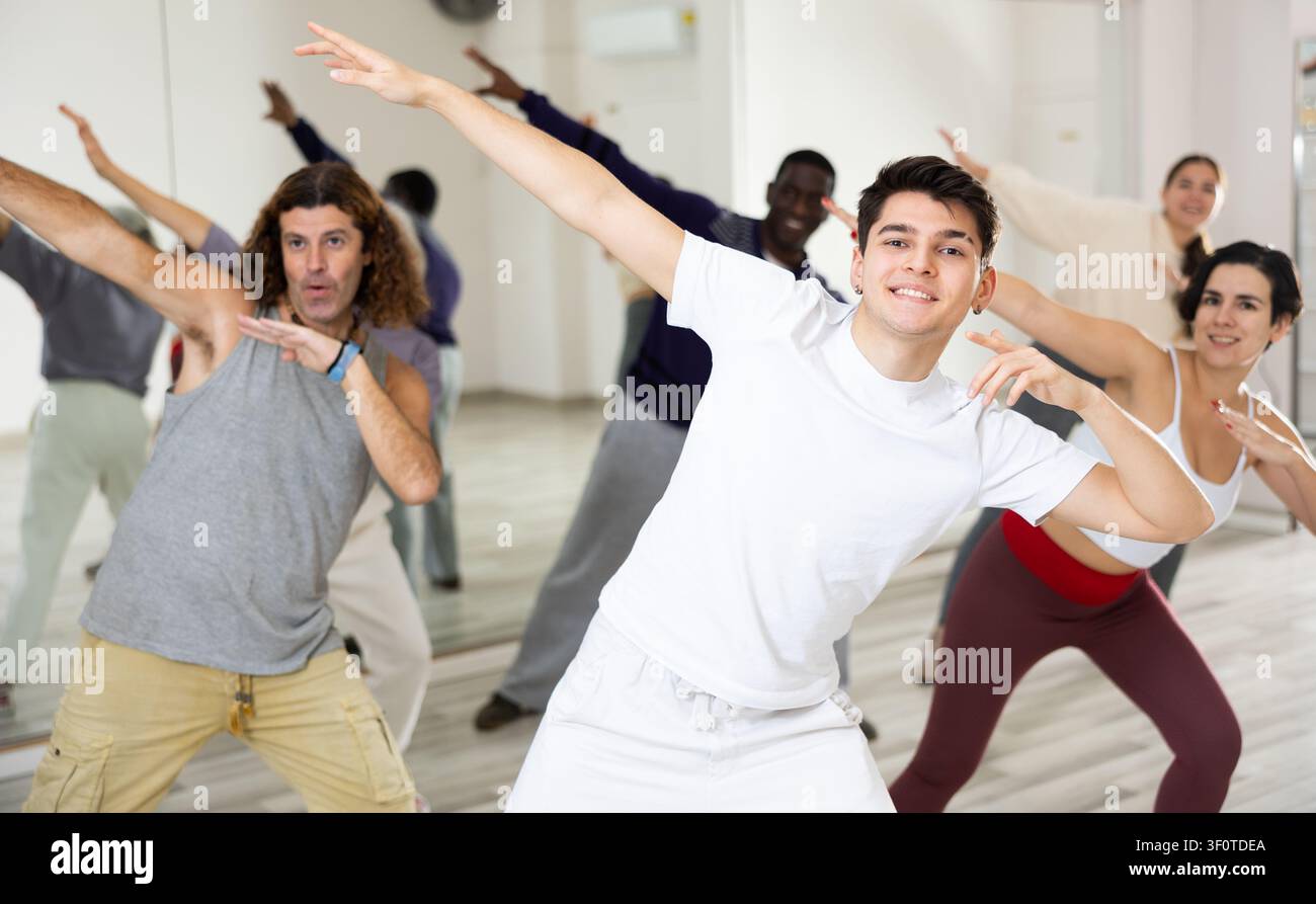 Cheerful guy practicing modern vigorous dance with group Stock Photo