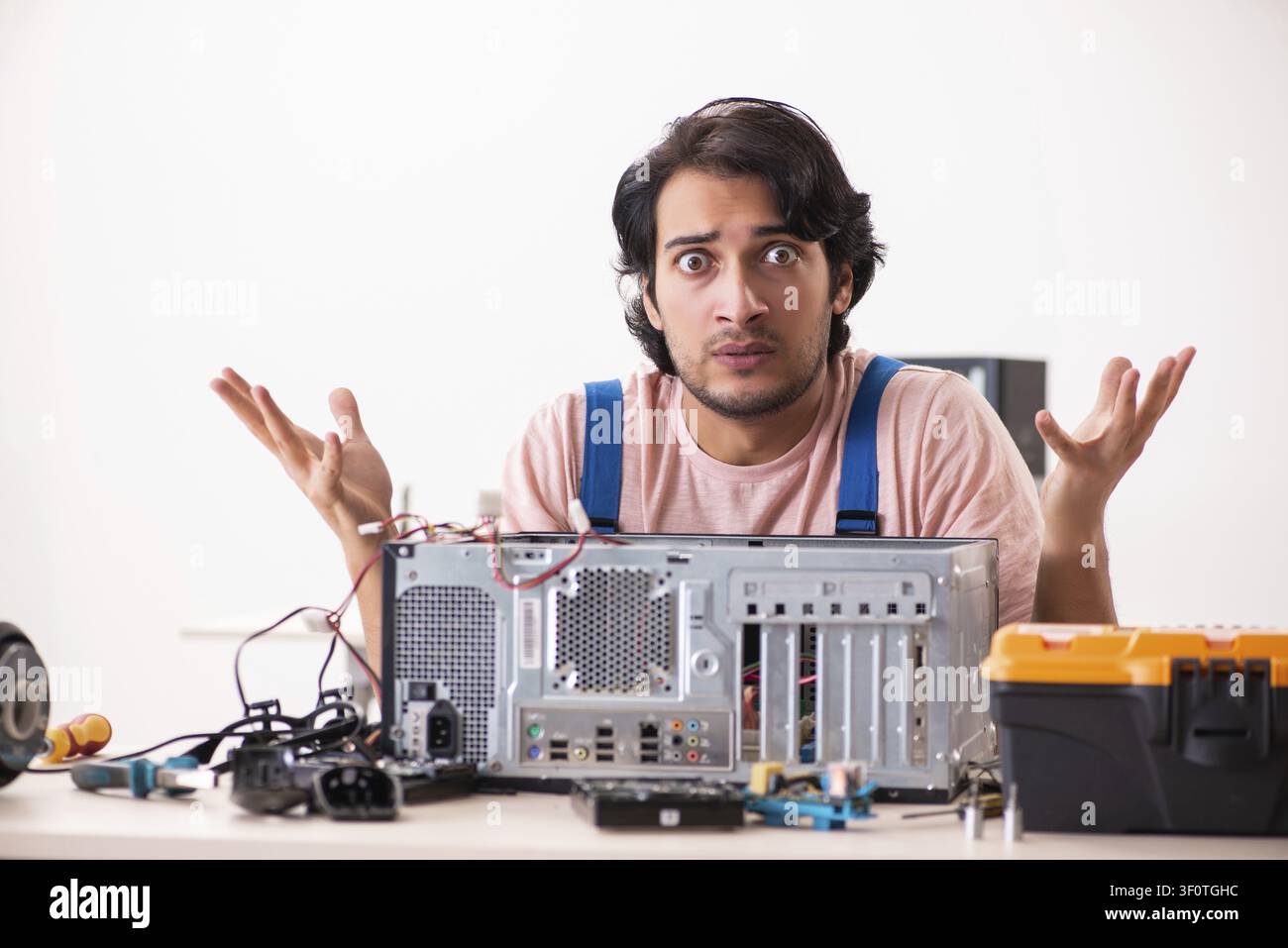 Young male contractor repairing computer Stock Photo