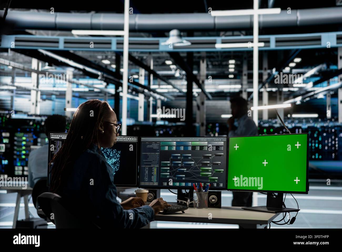 Server facility expert working with AI programming tools on green screen workstation to set up specialized hardware. Stock Photo