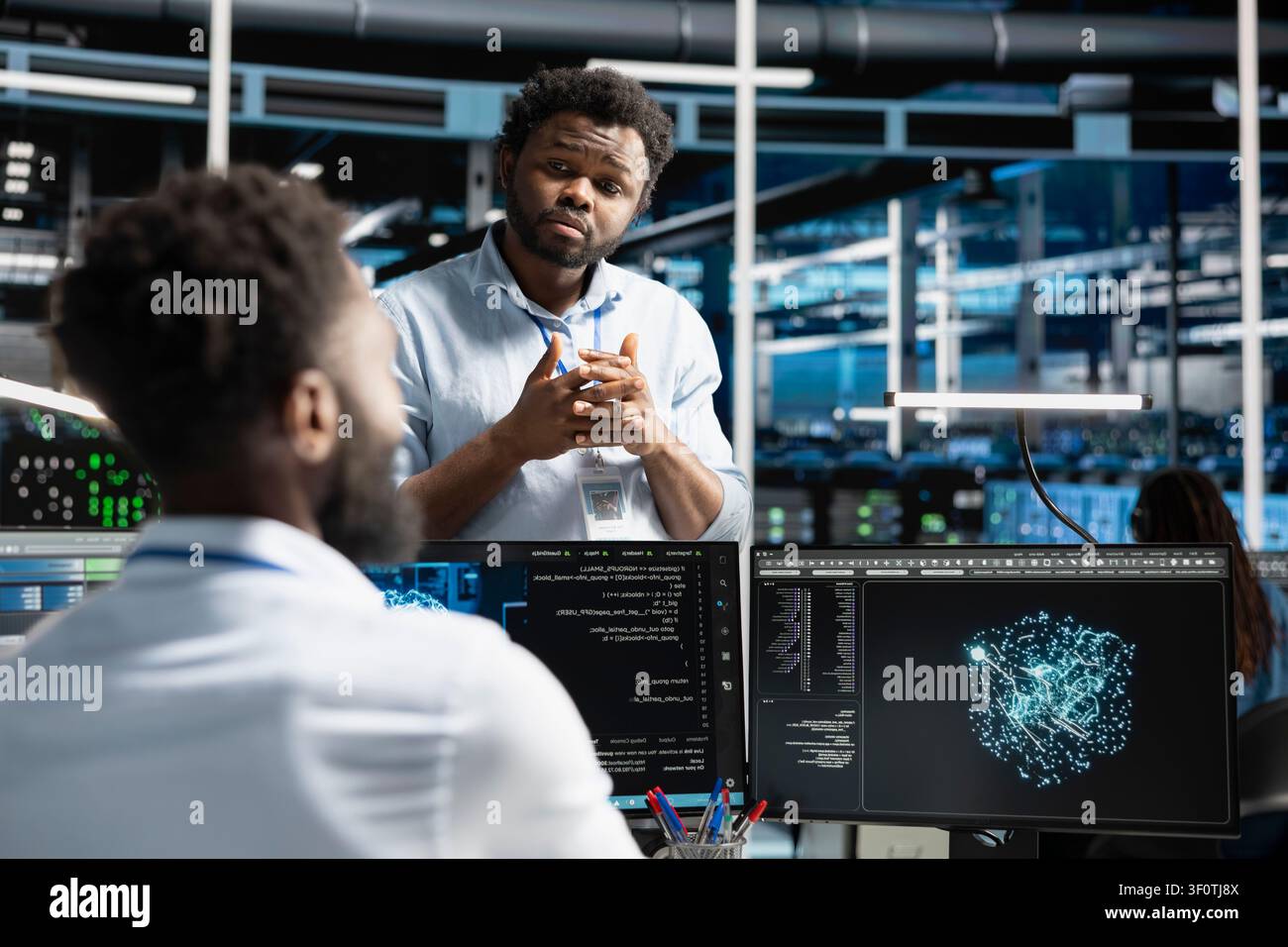 Data center manager supervising engineer reviewing data analysis graph to reduce failures. Stock Photo