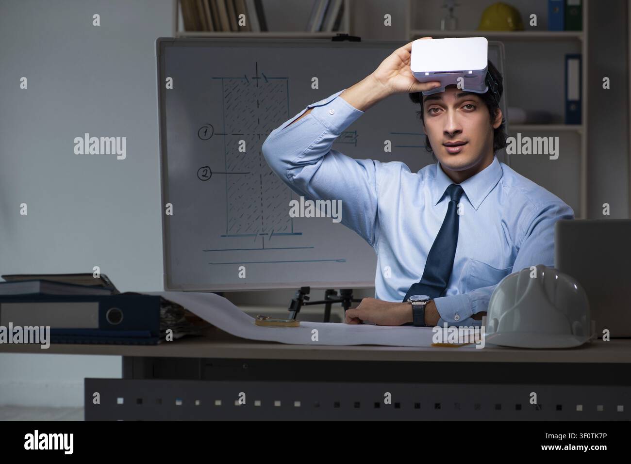 Young male architect working night at office Stock Photo