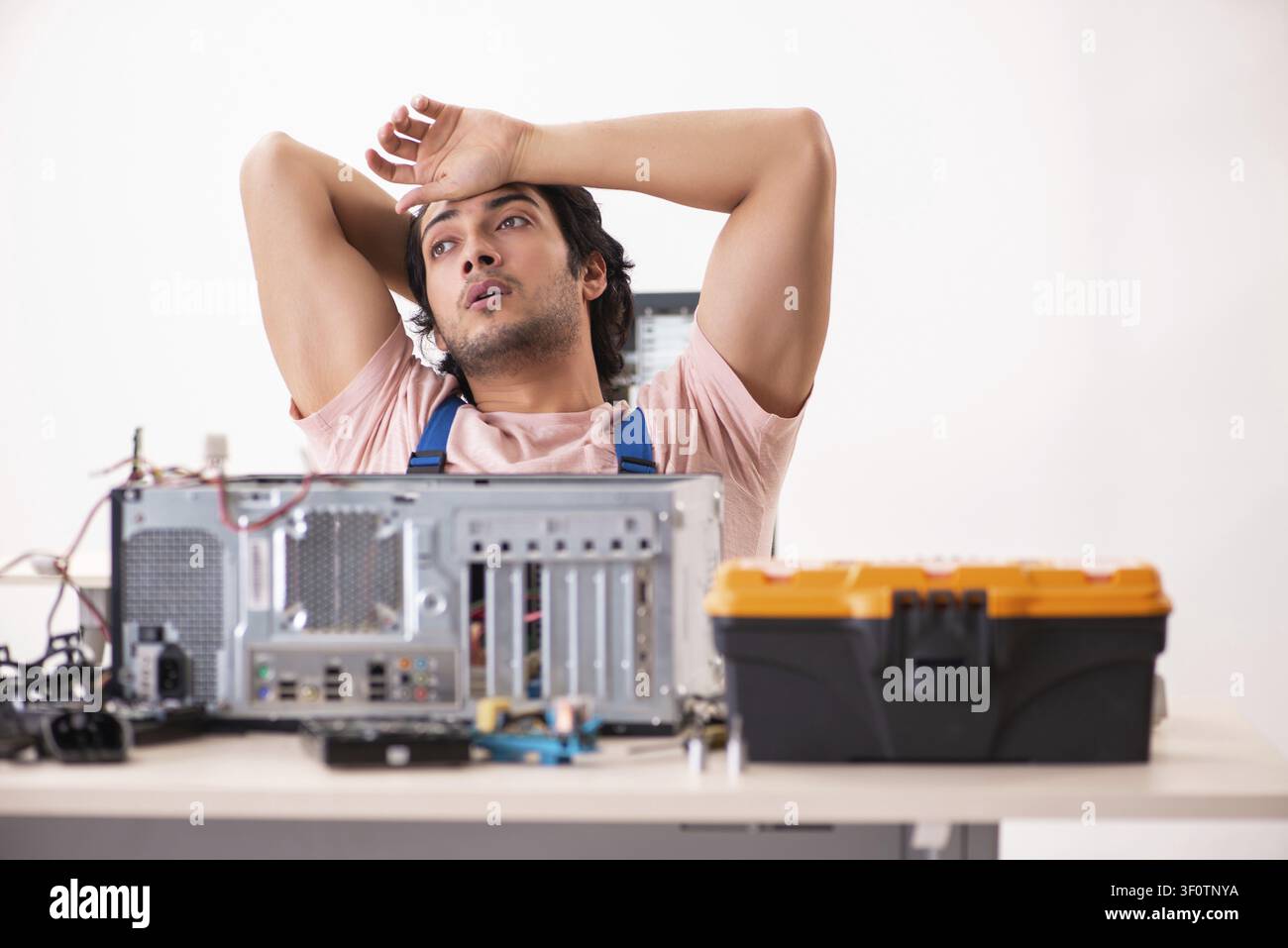 Young male contractor repairing computer Stock Photo
