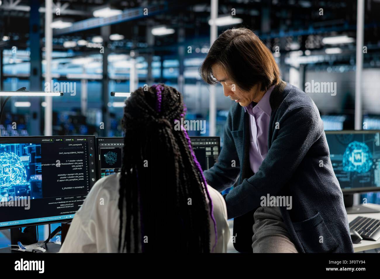 Data center manager reviews artificial intelligence systems and machine learning processes inside a data center. Stock Photo
