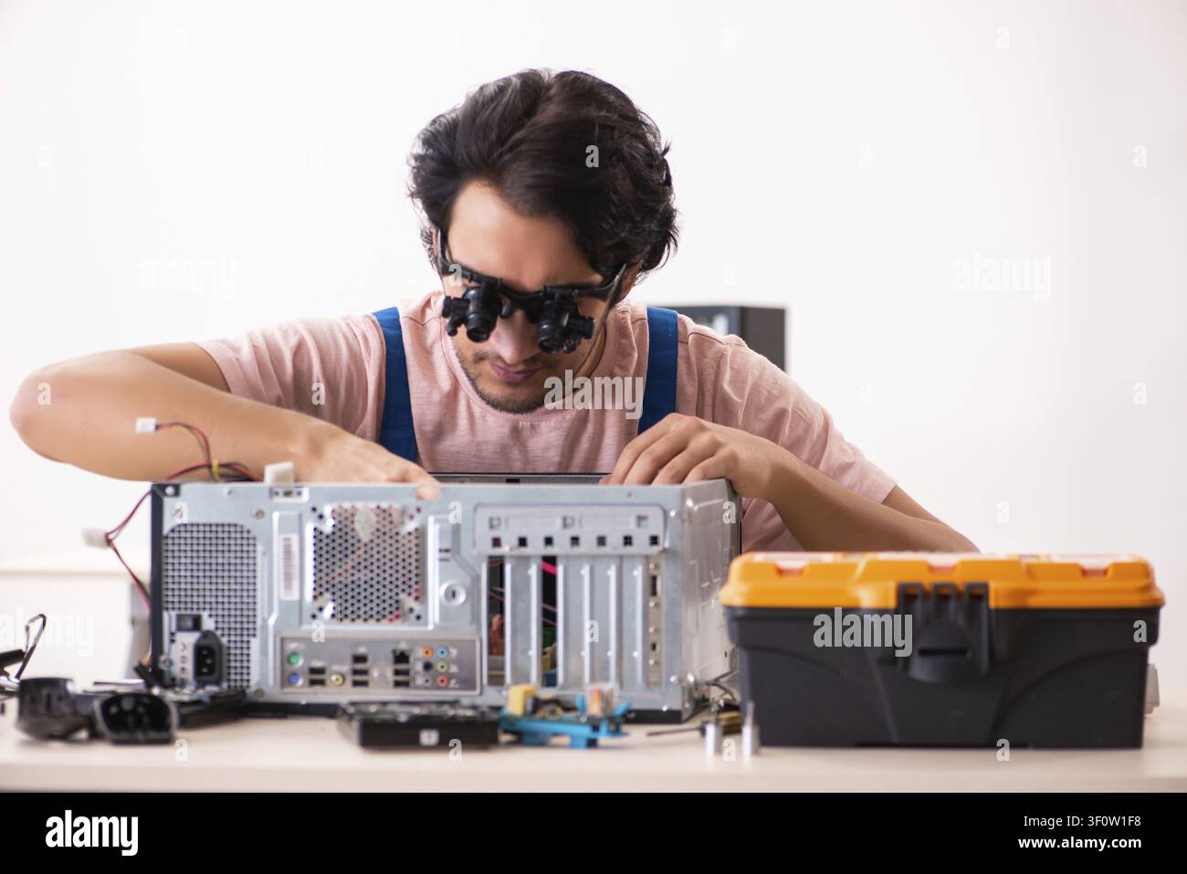 Young male contractor repairing computer Stock Photo
