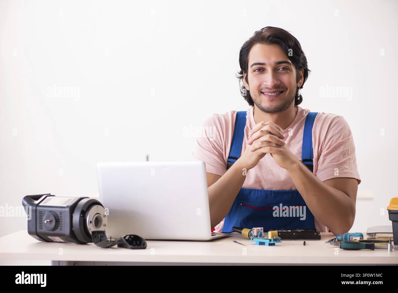 Young male contractor repairing computer Stock Photo