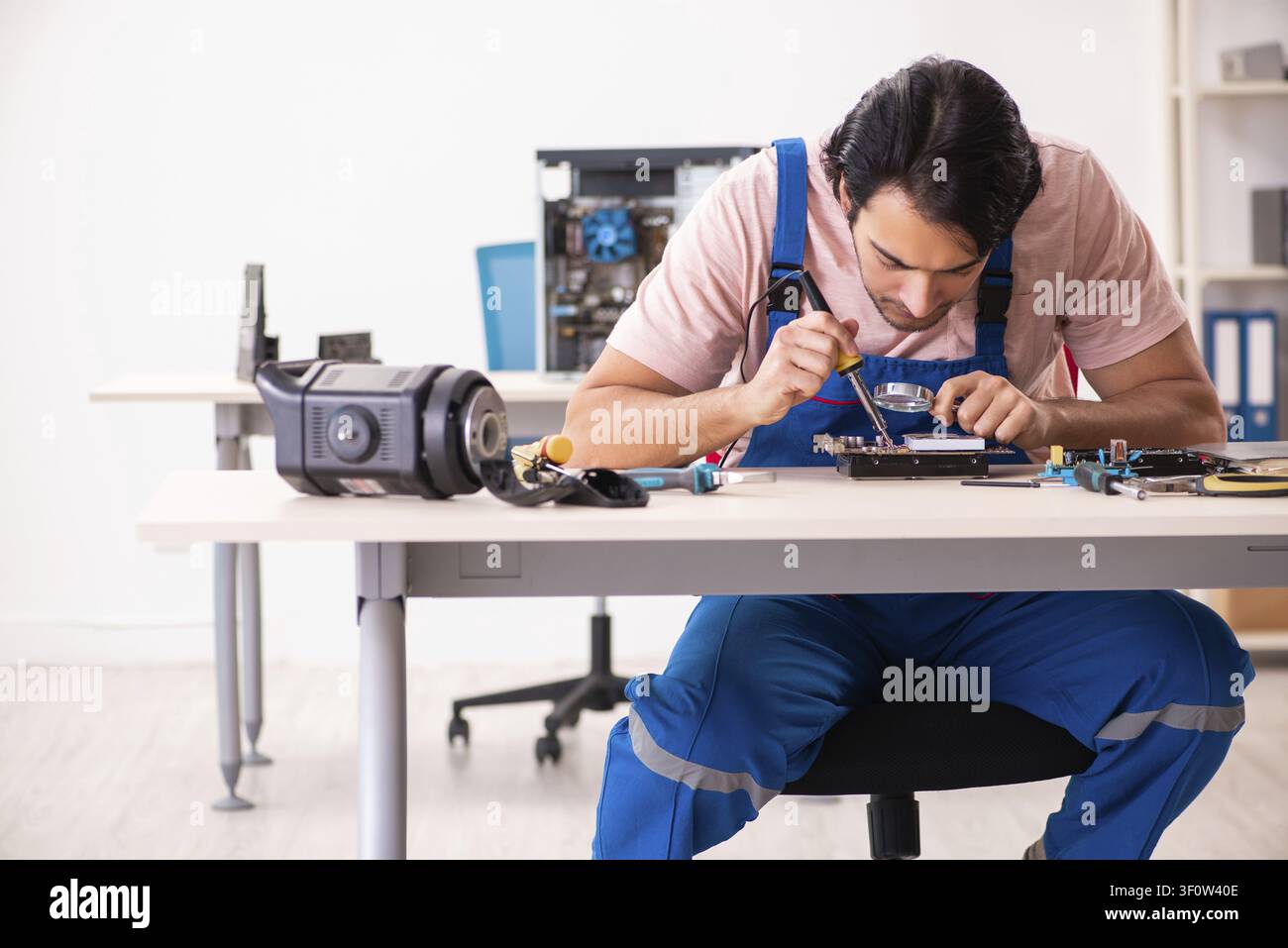 Young male contractor repairing computer Stock Photo