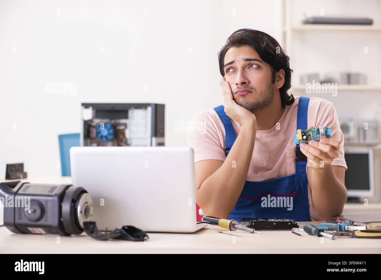 Young male contractor repairing computer Stock Photo