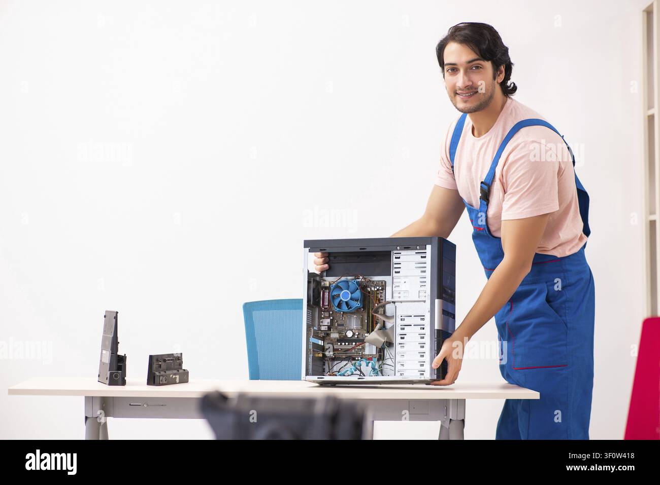 Young male contractor repairing computer Stock Photo