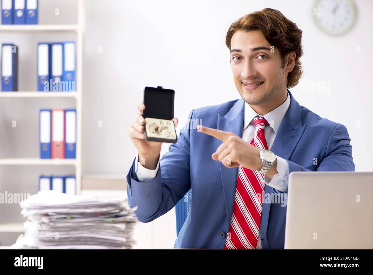 Deaf employee using hearing aid in office Stock Photo