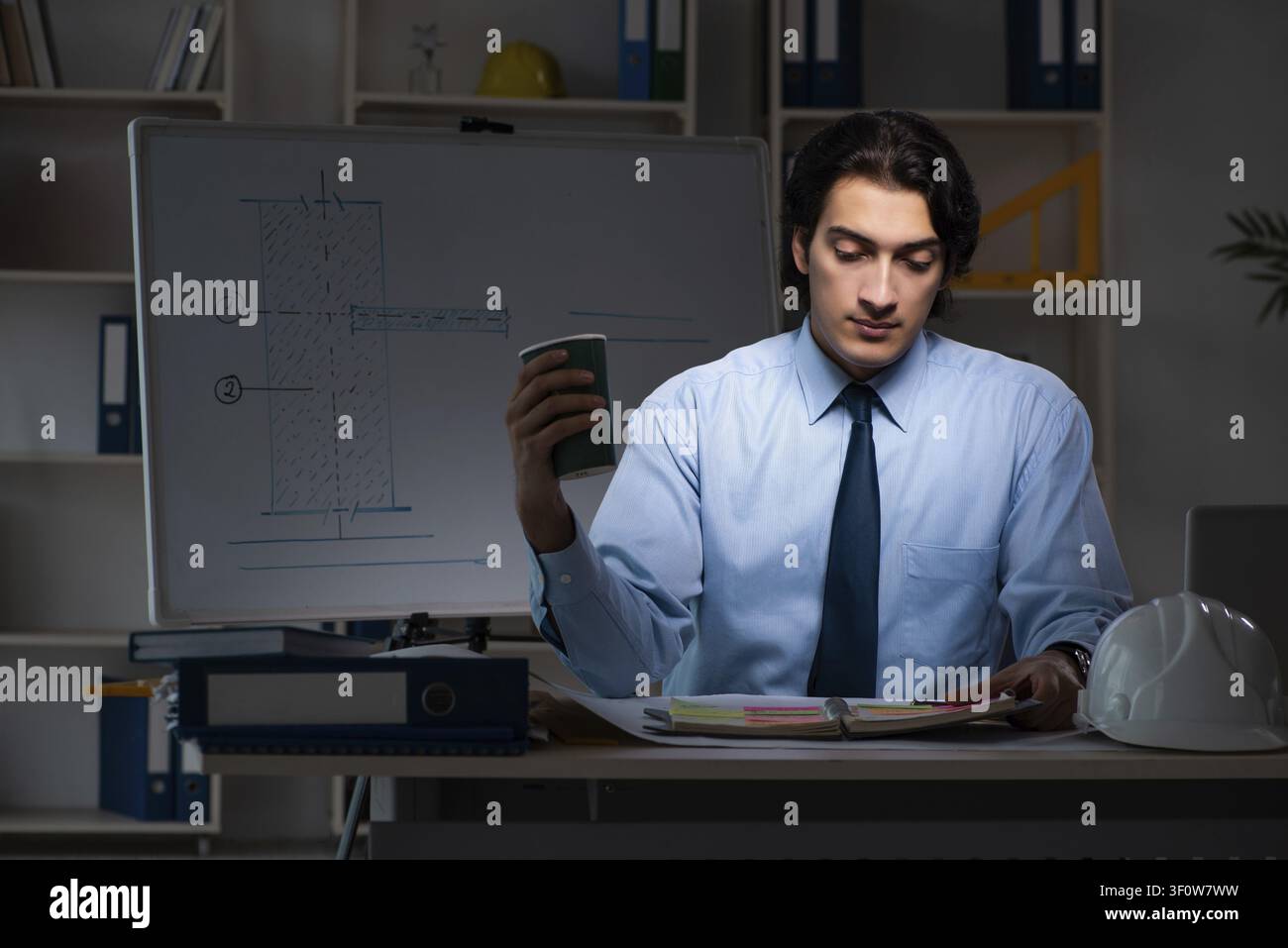 Young male architect working night at office Stock Photo