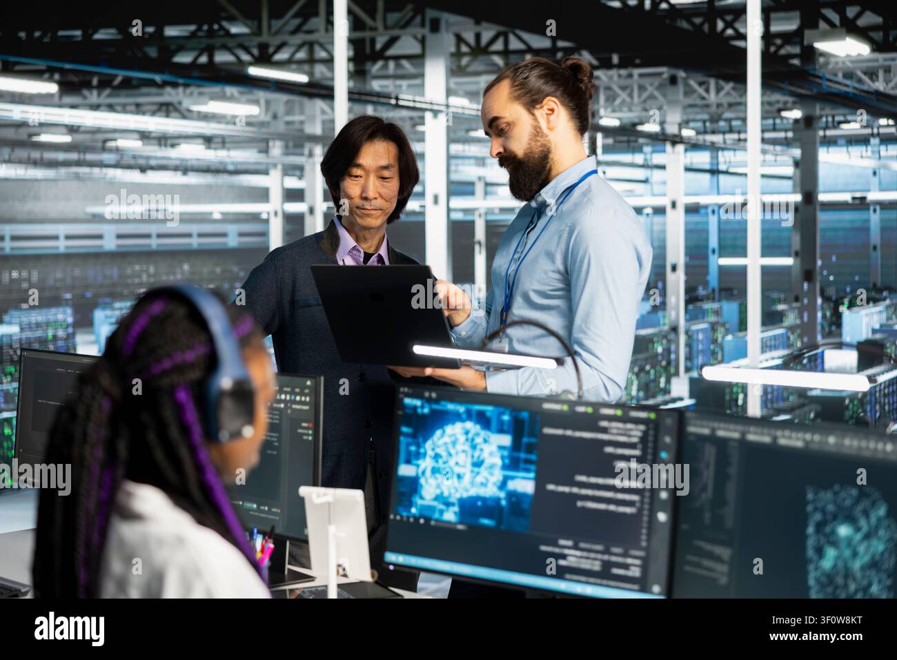 Programmers collaborating, coding in server room, updating deep learning scripts. Stock Photo