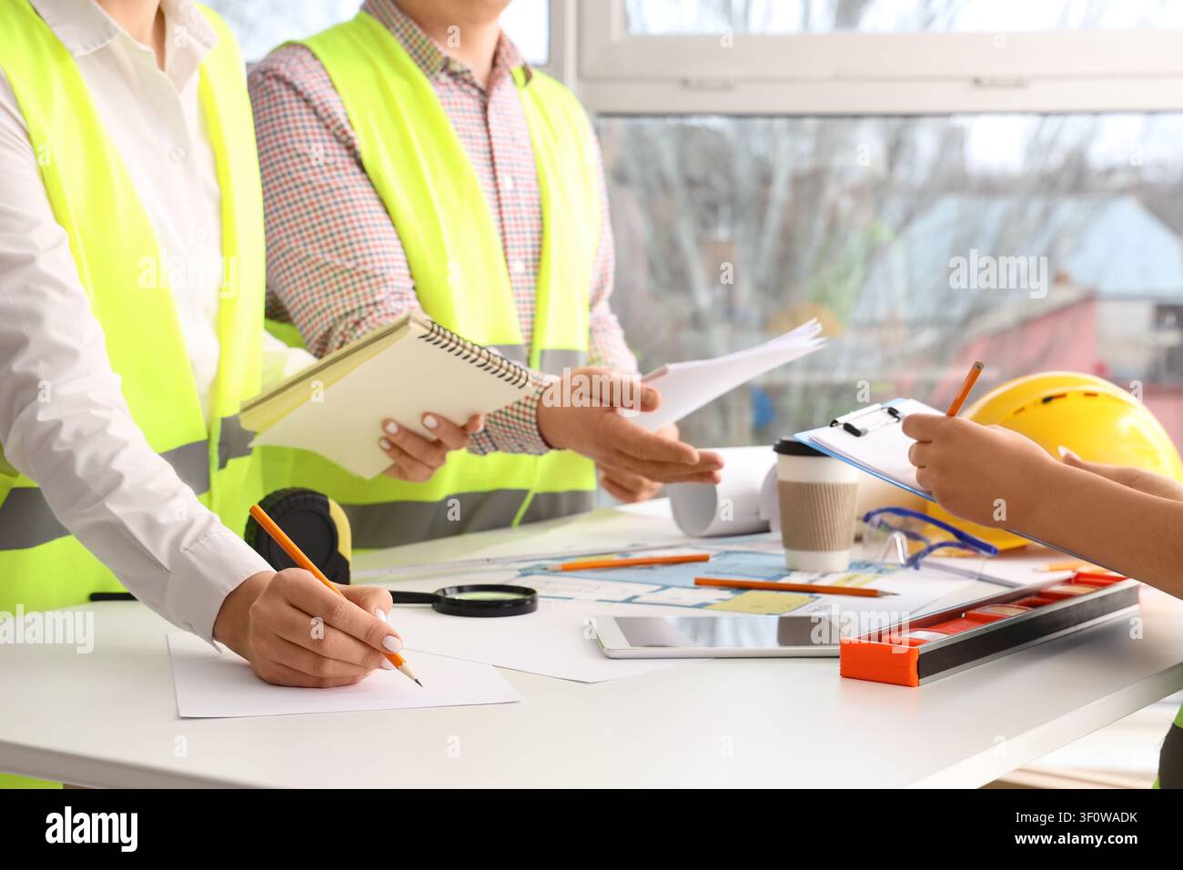 Team of constructors working at table in room Stock Photo