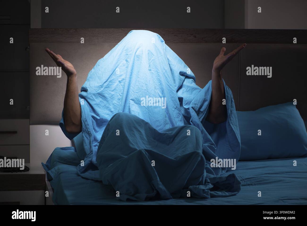 Young man scared in his bed having nightmares Stock Photo
