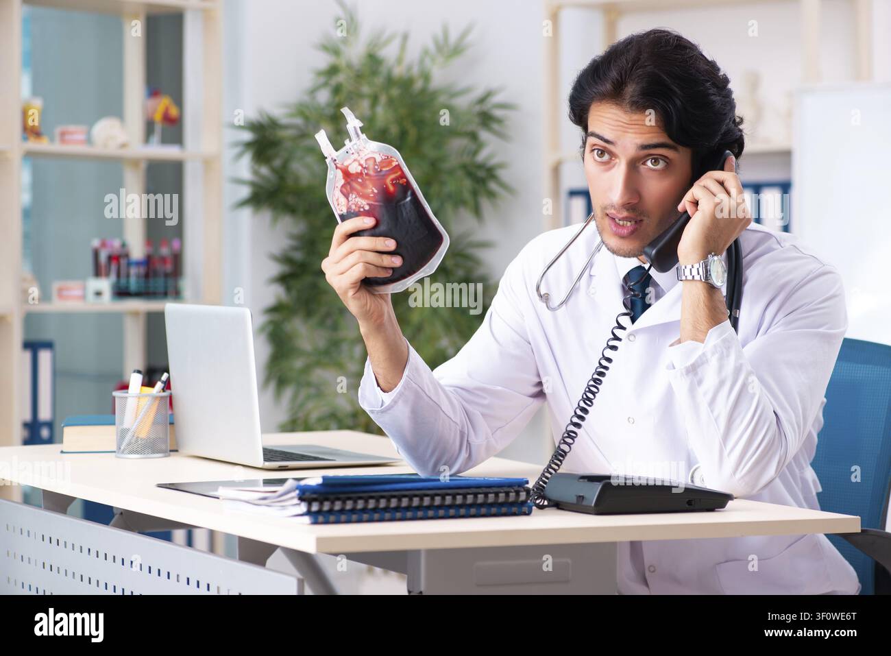 Young handsome doctor in blood transfusion concept Stock Photo