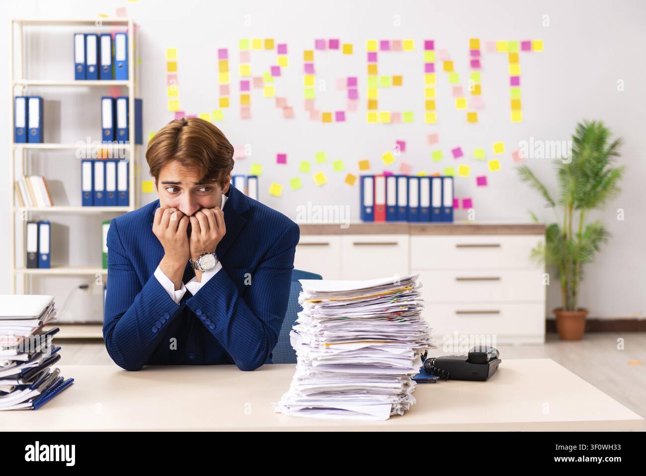 Young employee suffering from excessive work Stock Photo